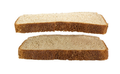 Slice of wheat bread suspended over another slice of wheat bread. Isolated.