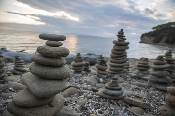 Fototapeta na wymiar Pile of pebbles in balance at sunset