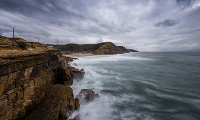 Rocky beach in Portugal in a stormy winter day. S.Juliao beach in ericeira