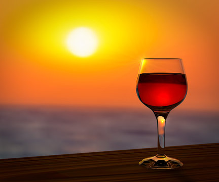 Red wine glass at the summer sunset romantic background.