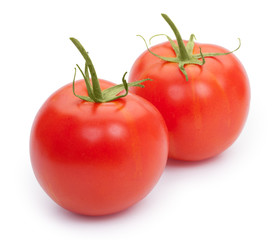 Two fresh tomatoes with green leaves isolated on white backgroun