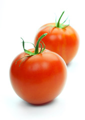 Two fresh tomatoes with green leaves isolated on white backgroun