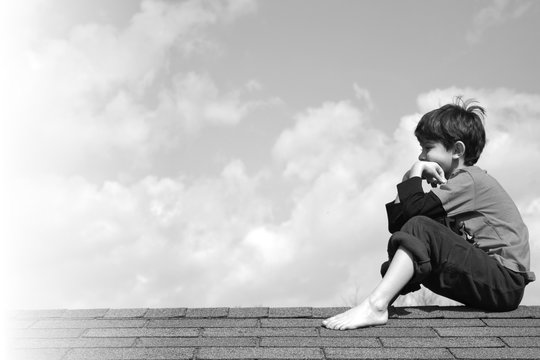 Kid on rooftop contemplating