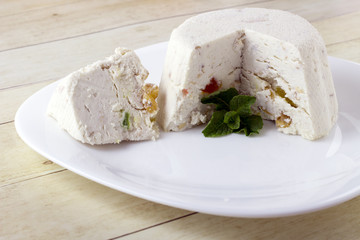 Curd cheese pudding with walnuts, raising and dried fruits on light wood background