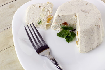 Curd cheese pudding with walnuts, raising and dried fruits on light wood background