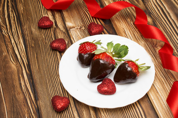 Fresh strawberries dipped in dark chocolate and heart on wooden background. Valentine's Day