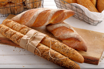 Fresh baguettes in bakery on wooden background