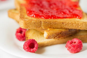 Toast with jam in white plate closeup
