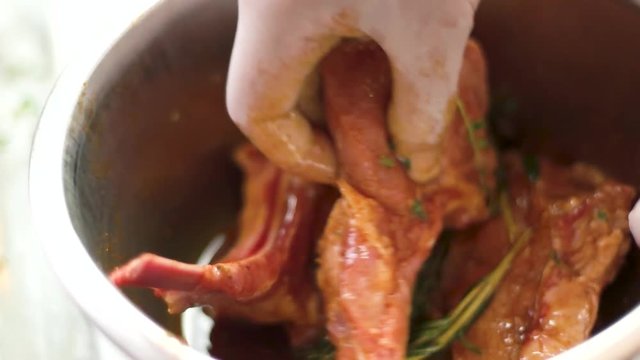 Meat with marinade in bowl. Raw steaks and rosemary.