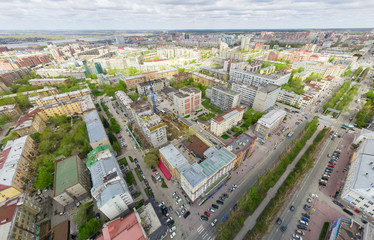 Fototapeta premium Aerial city view with crossroads and roads, houses, buildings, parks and parking lots, bridges. Copter shot. Panoramic image.