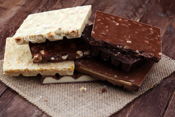 Chocolate bars on a wooden background with chocolate tower