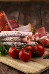 Food tray with delicious salami, pieces of sliced ham, sausage,