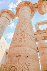 Obraz premium big stone columns with carving figures and hieroglyphs in landmark Egyptian Karnak Temple, public ancient monument declared a World Heritage by Unesco, in Luxor, Egypt, Africa 