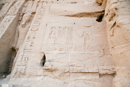 stone wall of egyptian Nefertari and Hathor Temple, with carved figures and hieroglyphs, with ceremony people, priest and goddess or queen, in Abu Simbel, Nubia, Egypt, Africa
