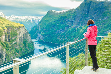 Tourist looking at Geirangerfjord from Flydasjuvet viewpoint Norway