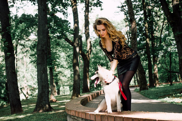 The girl with the siberian husky. Delightful girl plays with a Siberian Husky. Girl walking with a hunting dog - the West Siberian husky.