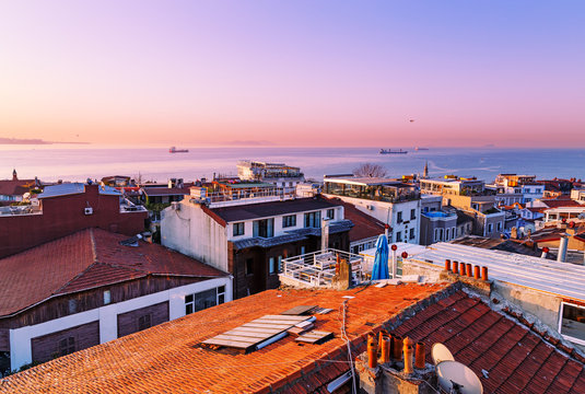 Beautiful view at Bosporus chanel over traditional turkish red roofs. Dawn scenery. Istanbul, Turkey.