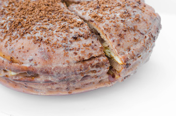 Chocolate cake with chocolate cream on plate, on light background.
