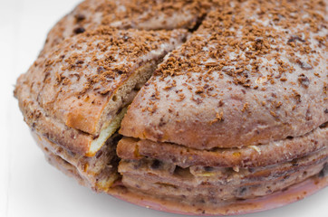 Chocolate cake with chocolate cream on plate, on light background.
