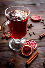mulled wine with spices in cup on wooden background