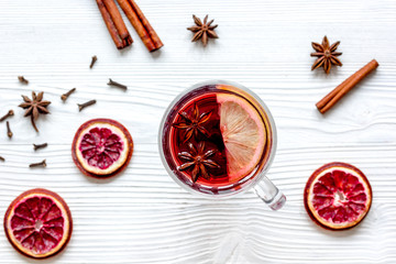mulled wine with spices in cup wooden background top view