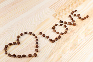 inscription love with coffee beans on the wooden table