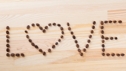 inscription love with coffee beans on the wooden table