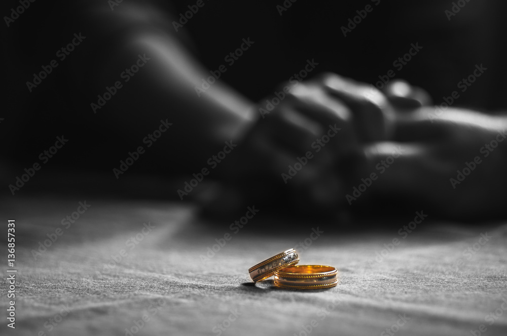 Wall mural Love, Valentine`s day and wedding concept. Two wedding rings with man and woman hands blurred in the background. Selective focus