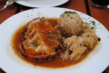 Plate of pork with sauerkraut and bread dumpling.