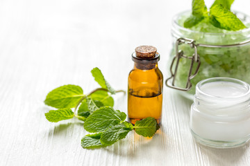 organic cosmetics with herbal extracts of mint on wooden background
