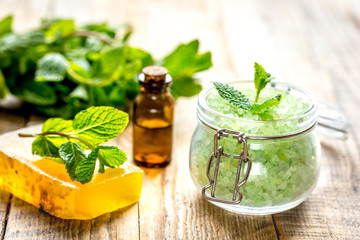 organic cosmetics with herbal extracts of mint on wooden background