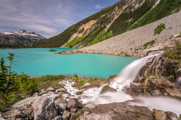 Fototapeta na wymiar Waterfall from Matier glacier melt water flowing into the Turquoise Upper Joffre Lake in Beautiful British Columbia, Canada