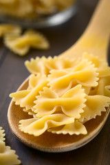 Rohe Farfalle Pasta auf Holzlöffel, fotografiert mit natürlichem Licht (Selektiver Fokus, Fokus ein Drittel in das Bild)