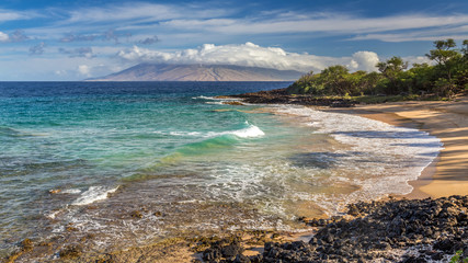 Fototapeta na wymiar little beach on the island of Maui, hawaii at sunrise with turquoise sea and a view of the west maui mountains before all the nudists arrive