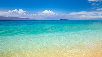 blue water at Makena Beach, Maui, Hawaii with Molokini crater at the horizon. Molokini is a...