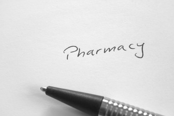 Handwritten word 'Pharmacy' on white paper