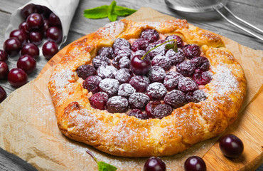 Open pie tart dough with ripe cherries