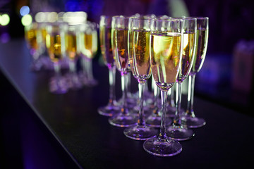 a lot of glasses of champagne on a table in a restaurant