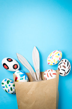 Easter bunny in a paper bag. Blue background. Easter ideas. Easter eggs. Space for text.