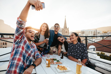 Friends on rooftop party taking selfie