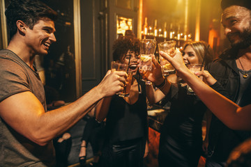 Group of men and women enjoying drinks at nightclub