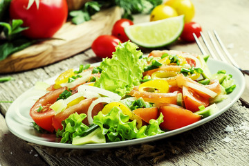Salad with salted salmon and vegetables. Vintage wood background