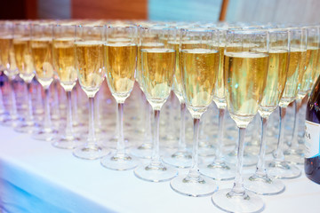 a lot of glasses of champagne on a table in a restaurant