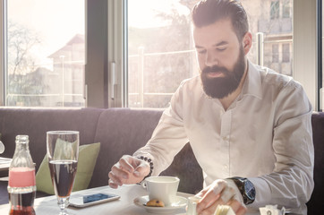 serious business man with a beard sitting in a cafe