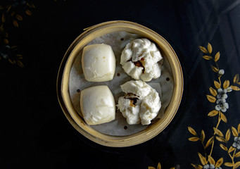 Dumplings and Chinese buns on plate in bamboo basket
