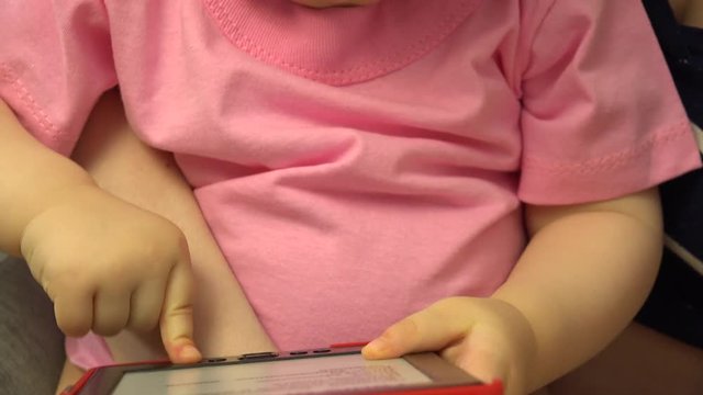 Happy Little Baby Girl Reading Electonic Book. 4K UltraHD video.