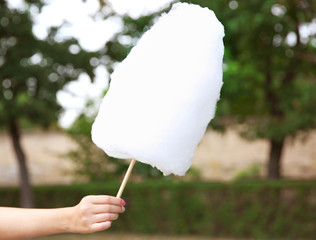 Female hand holding cotton candy outdoors