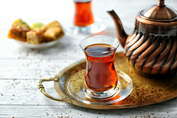 Turkish tea in traditional glass and metal teapot on wooden table closeup