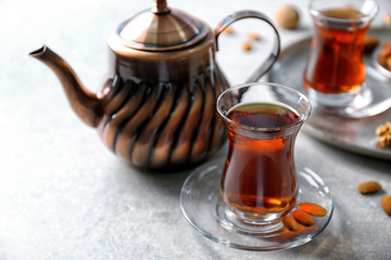 Turkish tea in traditional glass with nuts on table closeup