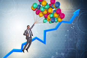 Businessman flying on balloons over graph